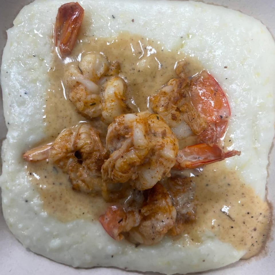 Shrimp and grits with a creamy sauce, a classic seafood dish from Brickhouse Seafood Cafe.