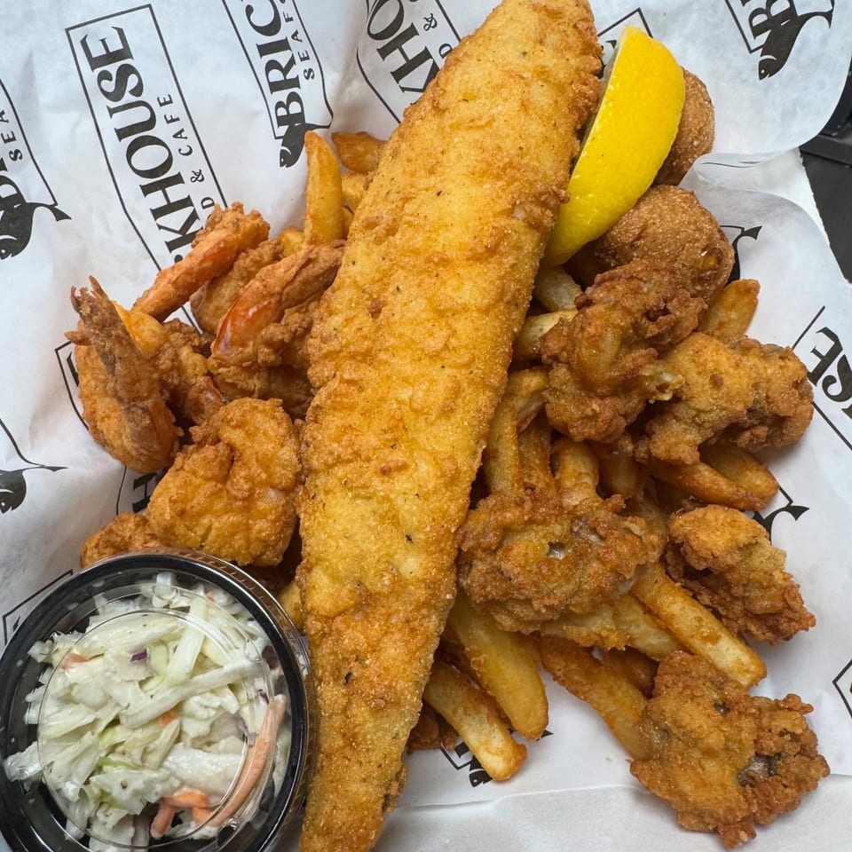 Fried fish, shrimp, oysters, and fries with coleslaw and a lemon wedge from Brickhouse Seafood Cafe.